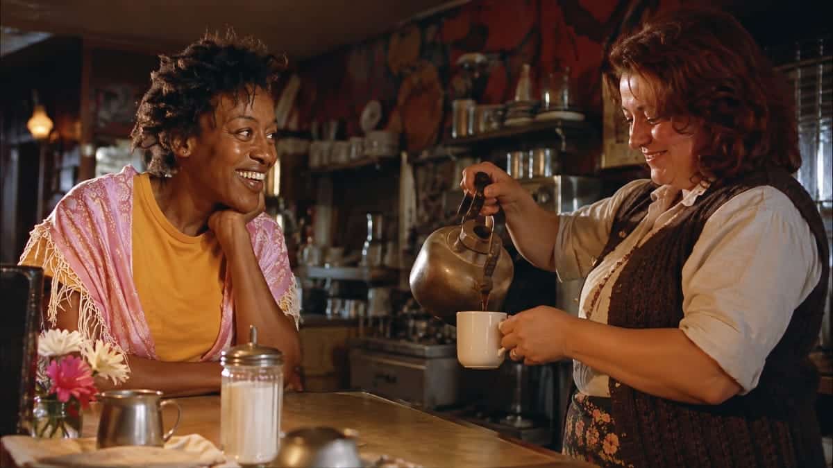 Brenda regarde Jasmin servir une tasse de café derrière le comptoir dans le film Bagdad Café